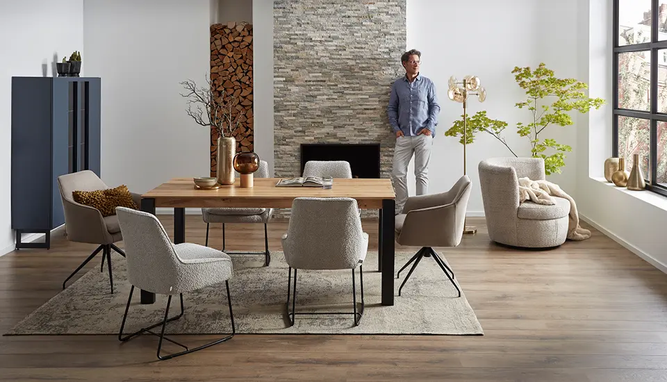 Landhausküche in Salbeigrün mit umlaufenden Rahmenfronten, gemustertem Fliesenboden, offenen Regalen und vielen Pflanzen unter warmem Deckenlicht.